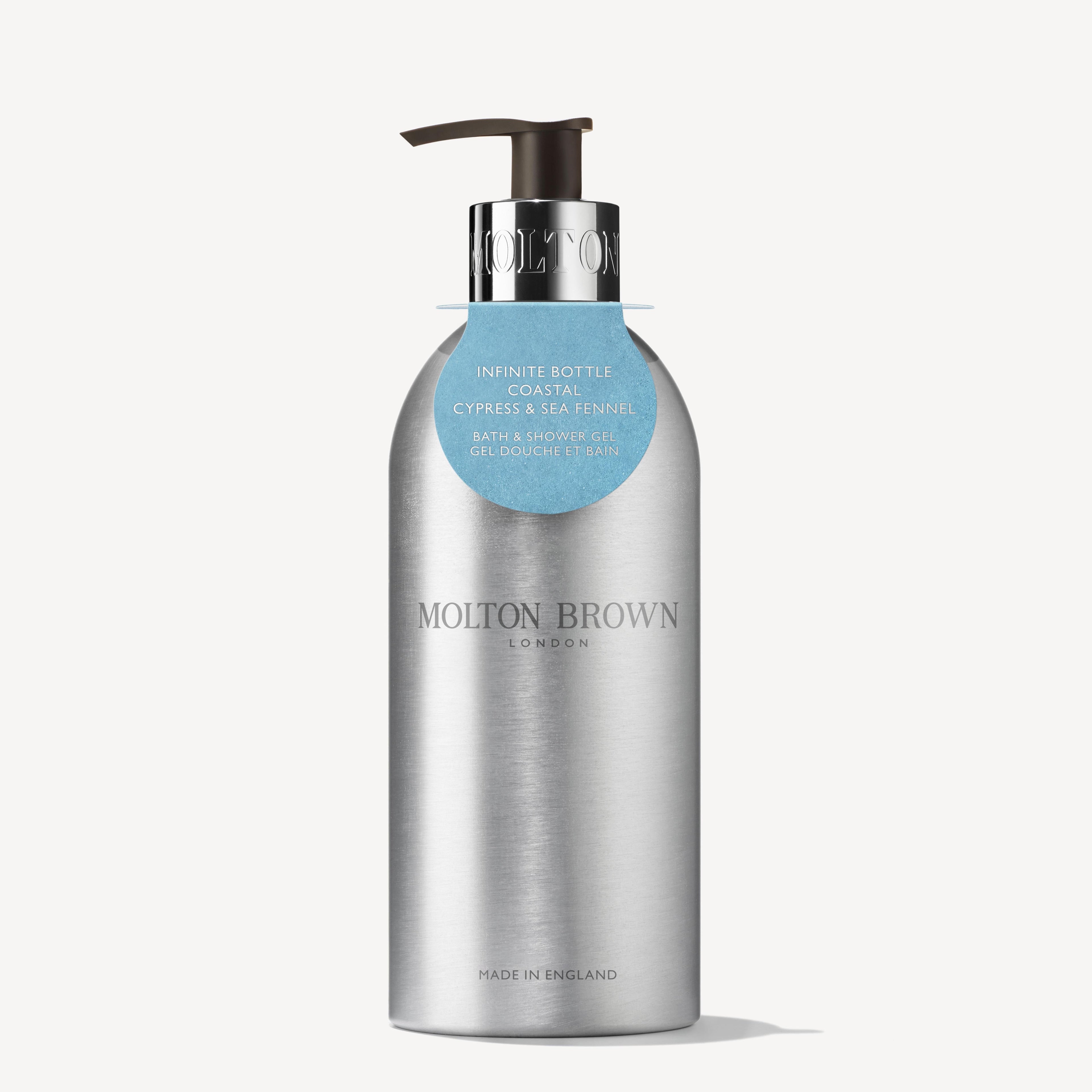 Een metallic gerecycleerde aluminium fles van MoltonBrown Nederlands, Coastal Cypress & Sea Fennel Navulbare Fles 400ml, met blauw label om de hals, tegen een witte achtergrond.